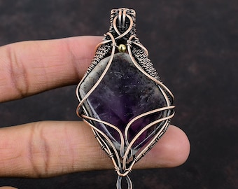 May include: A purple amethyst gemstone pendant wrapped in copper wire with a small gold bead at the top.