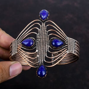 May include: A copper wire bracelet with a geometric design and four blue lapis lazuli stones.