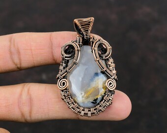 May include: A copper wire wrapped pendant featuring a white and gray agate stone with brown and yellow inclusions. The pendant has a detailed wire design with intricate swirls and loops.