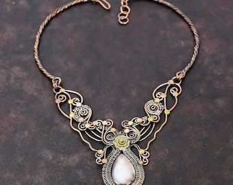 May include: A copper wire necklace with a delicate, intricate design featuring a large, pear-shaped, iridescent white stone pendant.