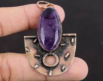May include: A copper pendant with a large oval amethyst gemstone set in a geometric design. The pendant has a textured surface and a circle in the center.