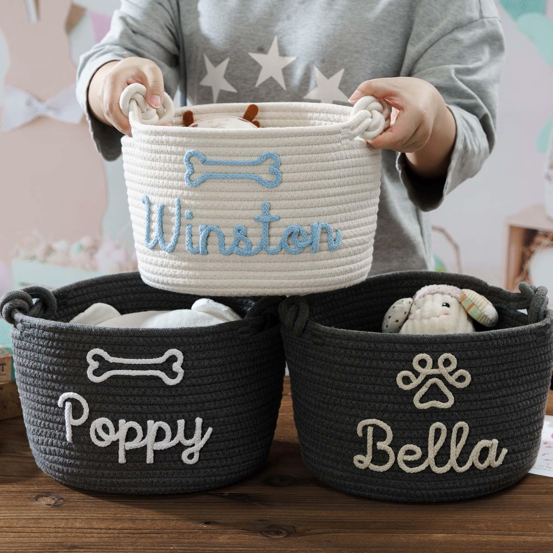 Three personalized handwoven dog toy baskets in black and white.
