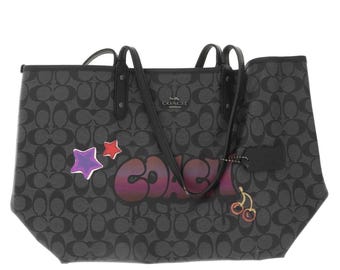 Coach Reversible City Tote in Signature Canvas with Multicolored Graffiti. Bag is grey and black. Handle drop is 10. Size: 11 × 17.5 x 6.