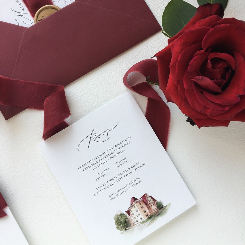 May include: A white RSVP card with black text and a watercolor illustration of a building. The text reads "Uprzejmie prosimy o potwierdzenie przybycia na przyjęcie weselne do 10 lipca 2020 roku."  The card also includes the names "Karolina" and "Gregors" with phone numbers.