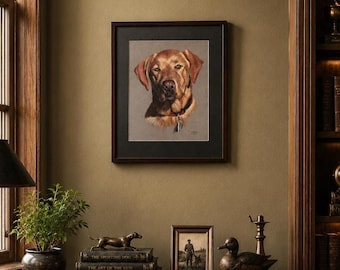 May include: A framed portrait of a golden Labrador Retriever with a dark brown frame hangs on a green wall. The dog is wearing a collar with a tag. A desk displays books, a small statue of a dog, a framed photo, and a duck statue.
