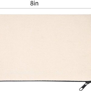 May include: A plain white canvas zipper pouch with a black zipper. The pouch measures 8 inches wide and 4 inches tall.