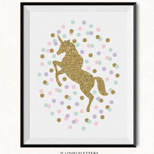 May include: A framed print featuring a gold glitter unicorn rearing up, surrounded by pastel confetti dots in pink, purple, and mint green. The print is on a white background and has a black frame. The Etsy shop name "LOVELYLETTERS" is at the bottom.