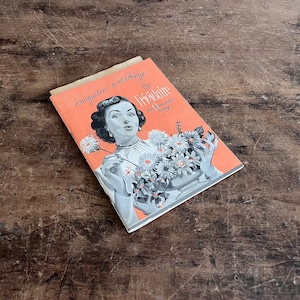 May include: A vintage pamphlet with a pink background and a woman blowing on a dandelion. The pamphlet reads "Carefree washing the "Tric-Lene" automatic way!"