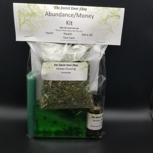 Peut inclure: Un sac en plastique transparent contenant une bougie verte, un savon vert, une petite bouteille d'huile et un sachet d'herbes s&eacute;ch&eacute;es. Le sac est &eacute;tiquet&eacute; "The Secret Door Shop Abundance/Money Kit" et comprend le texte "Money Flows Easily Into My Life."  "Health, Wealth, Fast Cash, Get a Job."  "The Secret Door Shop Money Drawing Incense."