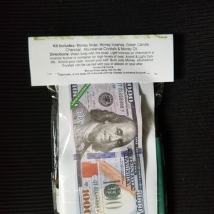 Peut inclure: Un kit pour les rituels d'argent, contenant une bougie verte, du savon pour l'argent, de l'encens, du charbon de bois, des cristaux et un billet de 1000 &euro;. Le kit comprend des instructions d'utilisation, y compris le texte "L'argent coule facilement dans ma vie." et "Historiquement, un billet de un euro est br&ucirc;l&eacute; avec l'encens pour renforcer son pouvoir."