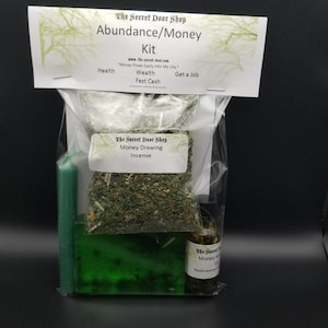 Peut inclure: Un sac en plastique transparent contenant une bougie verte, un savon vert, une petite bouteille d'huile et un sachet d'herbes s&eacute;ch&eacute;es. Le sac est &eacute;tiquet&eacute; "The Secret Door Shop Abundance/Money Kit" et comprend le texte "Money Flows Easily Into My Life."  "Health, Wealth, Fast Cash, Get a Job."  "The Secret Door Shop Money Drawing Incense."