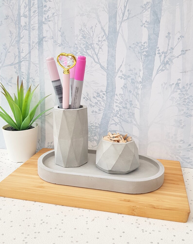 May include: A grey concrete desk organiser set with an oval tray, a pencil holder, and a small bowl. The set is on a wooden surface.