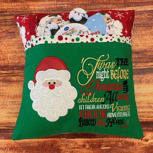 K&ouml;nnte beinhalten: Ein gr&uuml;nes Weihnachtskissen mit einem Santa Claus-Applikation und dem gestickten Text "Twas the night before Christmas". Das Kissen hat eine Tasche, die mit weihnachtlichen Gegenst&auml;nden gef&uuml;llt ist. Der obere Rand ist rot mit wei&szlig;en Punkten und Santa Claus-Illustrationen.