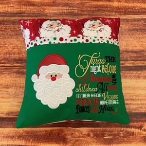 K&ouml;nnte beinhalten: Ein quadratisches Weihnachtskissen mit einer gr&uuml;nen Vorderseite, auf der ein gestickter Weihnachtsmann und der Text "Twas the night before Christmas" zu sehen sind. Der obere Rand ist rot mit Weihnachtsmann-Gesichtern und Schneeflocken.