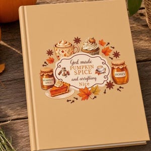 May include: A tan hardcover book featuring a central label with the text God made PUMPKIN SPICE and everything Nice. The design includes illustrations of a pumpkin spice latte, a cupcake, a jar of pumpkin spice, a slice of pie, and honey.