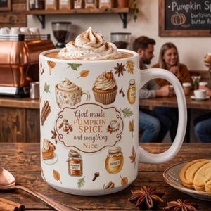 May include: A white ceramic mug filled with a beverage topped with whipped cream. The mug features a pattern of autumn-themed illustrations including a cupcake, honey jar, and leaves, with the text "God made PUMPKIN SPICE and everything Nice."