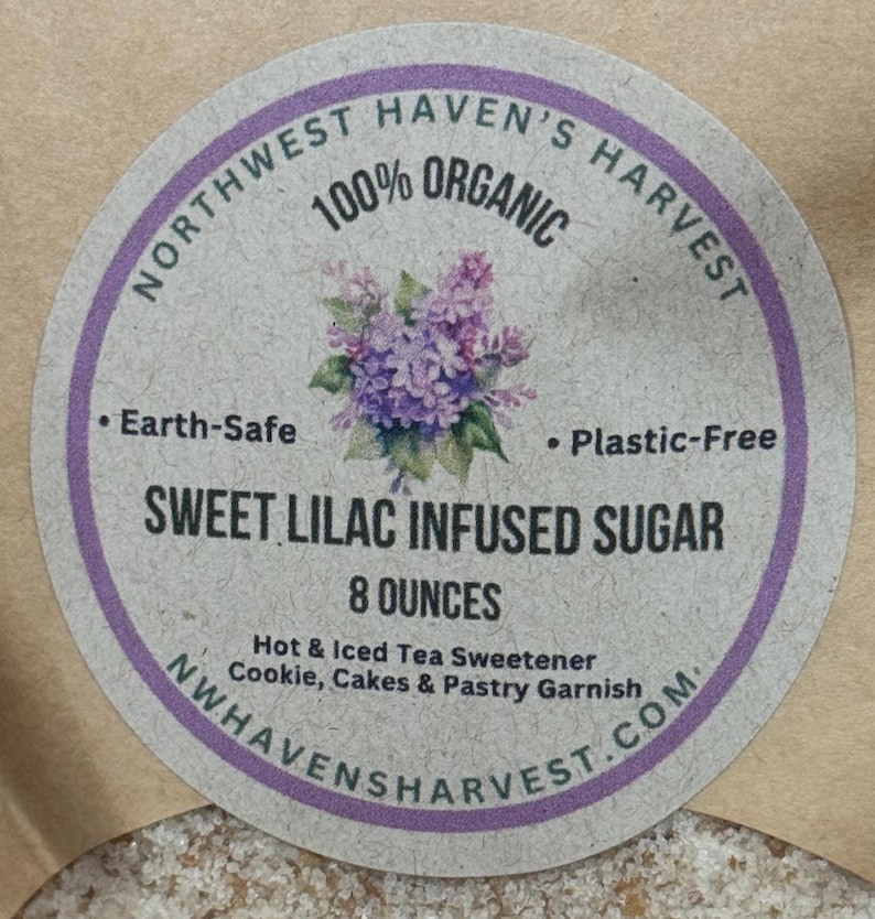 K&ouml;nnte beinhalten: Ein rundes Etikett mit lila Rand. Es tr&auml;gt die Aufschrift "Northwest Haven's Harvest 100% Organic" und zeigt eine Fliederbl&uuml;ten-Illustration. Das Etikett weist "Sweet Lilac Infused Sugar, 227 Gramm" aus. Es ist umweltfreundlich und plastikfrei.