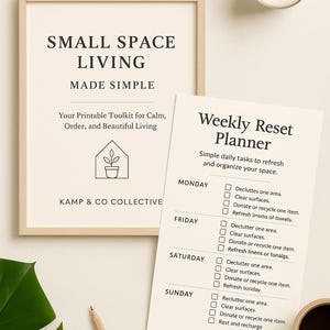 May include: A framed print with the text "SMALL SPACE LIVING MADE SIMPLE" and a "Weekly Reset Planner" checklist. A lit candle and a cup of coffee are also visible. A pencil and a large green leaf are in the foreground.