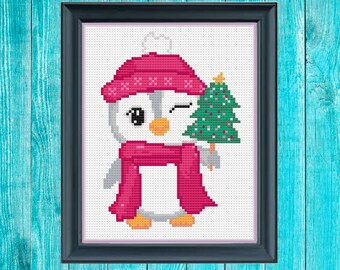 May include: A white penguin wearing a pink hat and scarf holds a small green Christmas tree with a gold star on top.