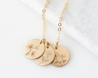 May include: Gold necklace with three round pendants featuring delicate floral designs. Each pendant has a different floral motif, creating a unique and elegant look.