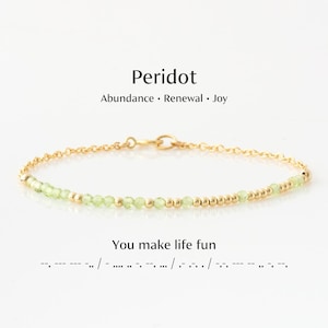 May include: A delicate gold bracelet featuring peridot gemstones and gold beads. The bracelet is adorned with small, light green peridot stones and gold beads. Text on the image reads "Peridot" and "You make life fun."