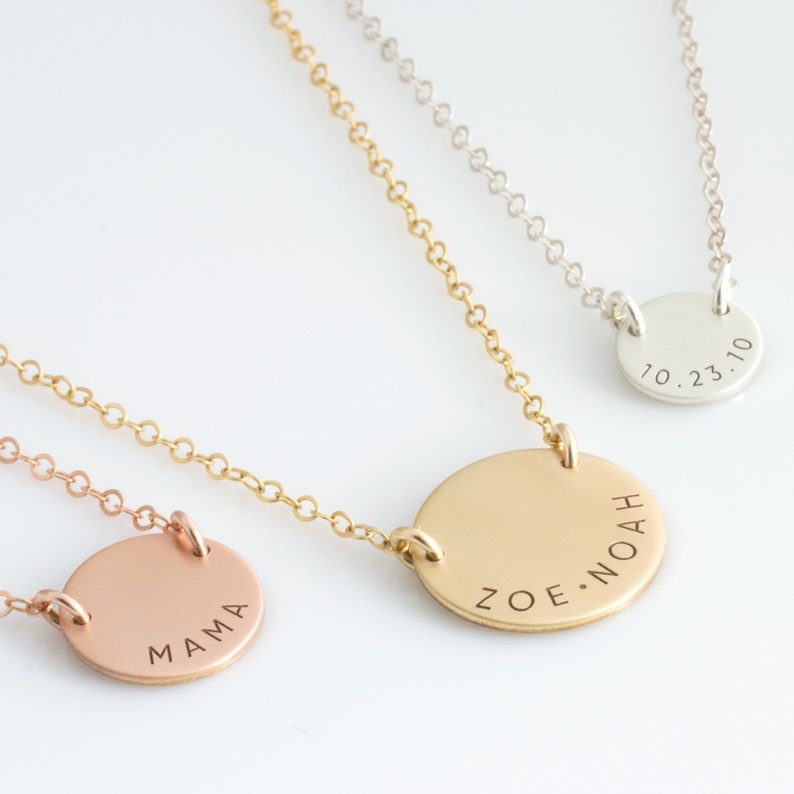 May include: Three gold necklaces with round pendants. The pendants are engraved with the words "Mama", "Zoe Noah", and "10.23.10".
