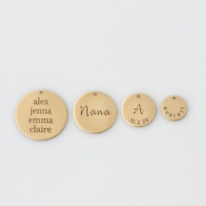 May include: Four gold-colored metal discs with engraved text. The largest disc reads "alex jenna emma claire". The next largest disc reads "Nana". The third disc reads "A 10.2.20". The smallest disc reads "everett".