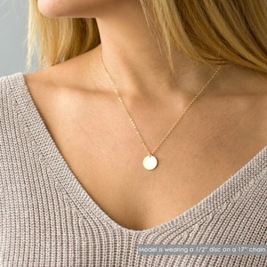 May include: A gold chain necklace with a 1/2 inch round pendant. The model is wearing a 17 inch chain.