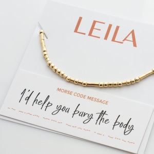 May include: Gold beaded bracelet with a card that says "LEILA" and "Morse Code Message: I'd help you bury the body".