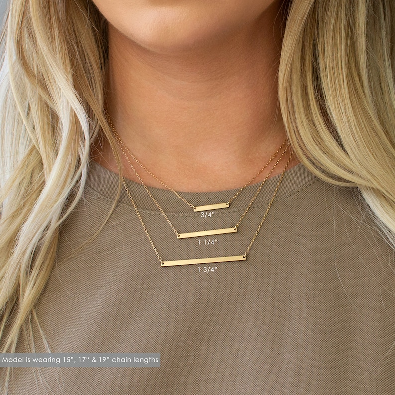 Puede incluir: Tres collares de barra de oro de diferentes longitudes, 3/4 pulgadas, 1 1/4 pulgadas y 1 3/4 pulgadas. La modelo lleva cadenas de 15", 17" y 19".