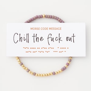 May include: A beaded bracelet featuring alternating matte mauve and metallic gold beads, displayed on a white card with the text MORSE CODE MESSAGE and Chill the fuck out, accompanied by the corresponding Morse code dots and dashes in orange.