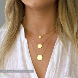 May include: A layered gold necklace with three circular pendants of different sizes. The model is wearing 15", 17", and 19" chain lengths.