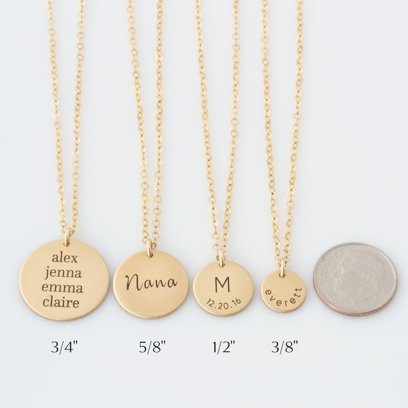 May include: Five gold necklaces with different sized round pendants. The pendants are engraved with names and dates. The necklaces are shown against a white background. The pendants measure 3/4 inch, 5/8 inch, 1/2 inch, and 3/8 inch.
