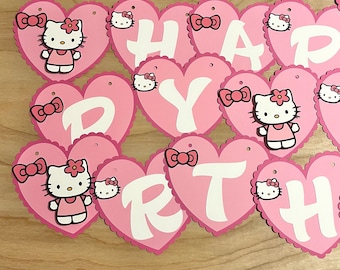May include: Pink and white heart-shaped banner with the words "Happy Birthday" and Hello Kitty characters.