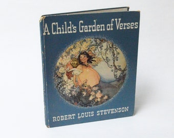 Può includere: Un libro blu intitolato "A Child's Garden of Verses" di Robert Louis Stevenson. La copertina presenta un'illustrazione di due bambini in un giardino.