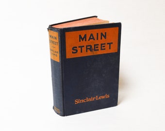 May include: A vintage hardback book titled "Main Street" by Sinclair Lewis. The book cover is dark blue with an orange title and author's name.