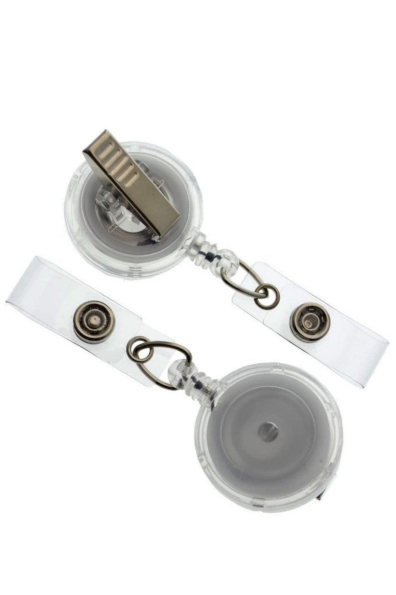 May include: Two clear retractable badge reels with a silver clip and a clear plastic badge holder.