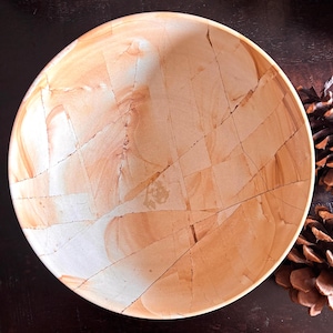 May include: A round, handcrafted bowl with a unique, cracked pattern. The bowl features a blend of beige and light brown tones, creating a natural, earthy aesthetic. The design resembles a mosaic or a fractured stone surface.