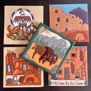 May include: Four square ceramic tiles featuring Southwestern designs. One tile shows a bison in a mountain landscape, another depicts a pueblo dwelling, a third shows a bird motif with corn, and the fourth displays a house with the text Mi Casa Es Su Casa.