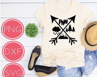 May include: A beige t-shirt with a black graphic design featuring a mountain range, a rain cloud, a pine tree, and two arrows crossed with the text "PNW".