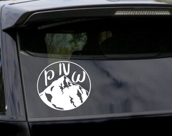 May include: A black car with a white sticker on the back window. The sticker features a mountain range with the letters "PNW" inside a circle. The car has a red taillight. The sticker is available in PNG, DXF, and SVG formats.