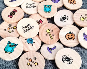 May include: A collection of round wooden discs featuring hand-drawn Halloween illustrations including pumpkins, owls, spiders, witch hats, wands, candy, and spiderwebs. Two discs are inscribed with the text Happy Halloween in black ink.