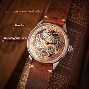 May include: A vintage wristwatch with a brown leather strap. The watch face has a skeleton design, revealing the internal mechanisms. The watch has a silver case with gold and copper detailing. The text on the watch face includes "WILLIAM VINTAGE ORIGINAL 1983 QUALITY LIMITED EDITION AGED TO PERFECTION".