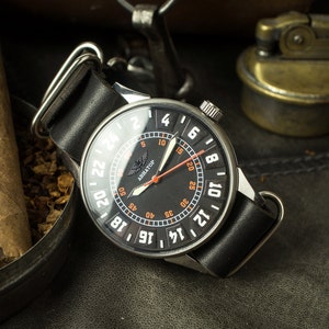 May include: A black wristwatch with a silver case and a black leather band. The watch face has a black background with white numbers and a red second hand. The watch face also has the word "ABHATOP" printed on it.