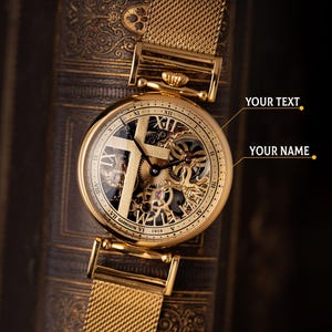 May include: Close-up of a gold-toned wristwatch with a mesh band. The watch face reveals intricate mechanical components and Roman numeral hour markers. The watch is set against a dark, textured background.