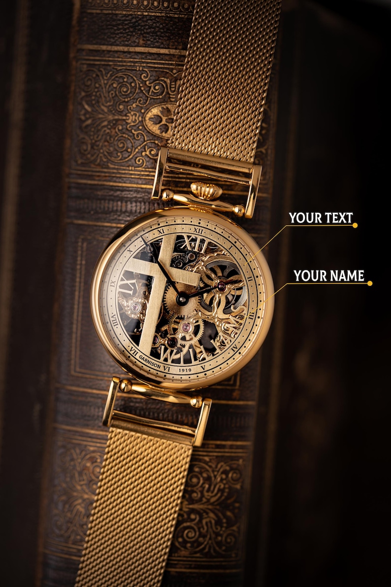 May include: Close-up of a gold-toned wristwatch with a mesh band. The watch face reveals intricate mechanical components and Roman numeral hour markers. The watch is set against a dark, textured background.