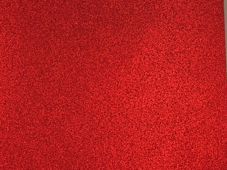 Peut inclure: Un gros plan sur une feuille de papier rouge paillet&eacute;. Le papier a une texture fine et uniforme et une finition brillante.