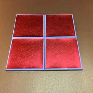 Peut inclure: Quatre sous-verres carr&eacute;s rouges avec une bordure blanche. Les sous-verres ont une surface textur&eacute;e.