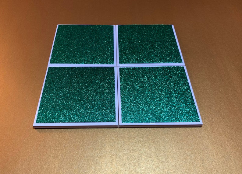 Peut inclure: Ensemble de quatre sous-verres carr&eacute;s en paillettes vertes avec des bordures blanches.