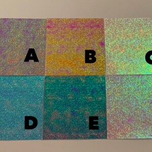 May include: Six iridescent samples of holographic vinyl, labeled A through F. The samples are arranged in two rows of three, with each sample showing a different color shift.